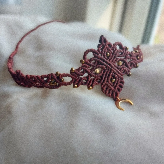 boho macrame choker featuring a lovely crescent moon charm that's plated with 18K gold, this necklace is the perfect statement piece for any hippie-style outfit. This versatile piece can be worn as a crew neck necklace or even as a tiara.