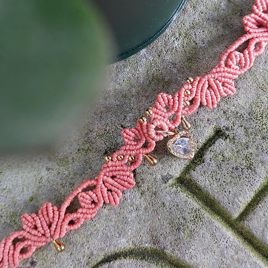 Elegant macrame choker in coral-pink with a sparkling Cubic Zirconia heart charm, perfect for bohemian and romantic jewelry lovers.