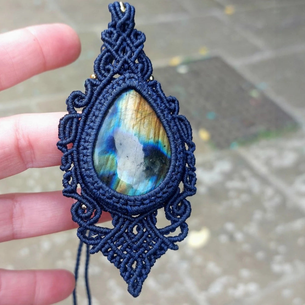 Macramé necklace featuring a large labradorite stone (42x30mm), framed with rich blue cord and fine decorative knotting.