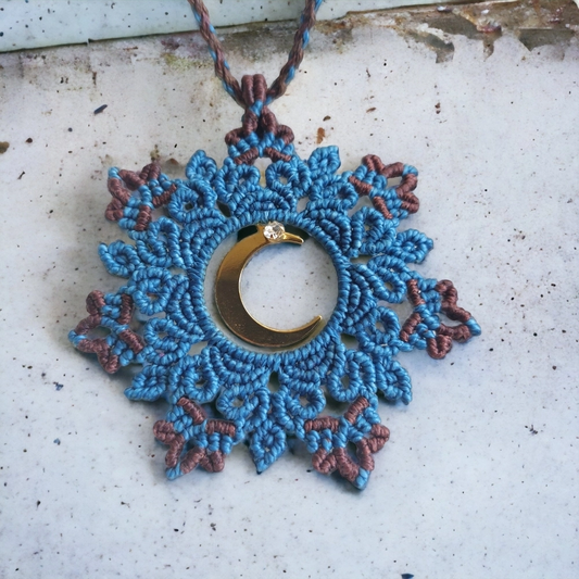 The light blue boho macrame mandala flaunts a crescent moon charm plated in 18K gold. Adjustable to 54cm/21.2 inches, including the pendant, it fits any neck with a slide lock feature.