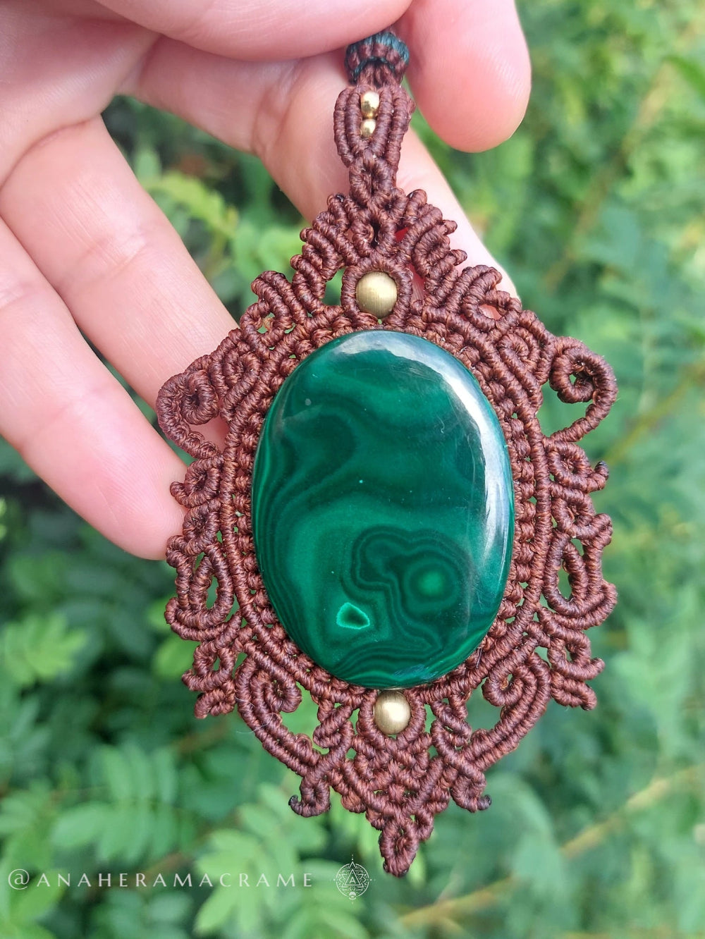 Earth-toned macrame necklace with polished malachite centerpiece and detailed knotwork.