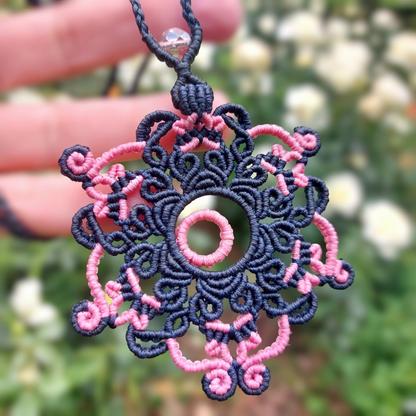 Close-up of the concentric pink circle design in a blue macrame mandala necklace.