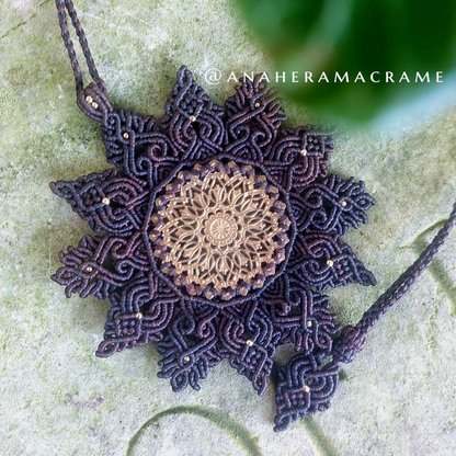 Bohemian-style necklace with brass filigree centerpiece and macrame details.  
