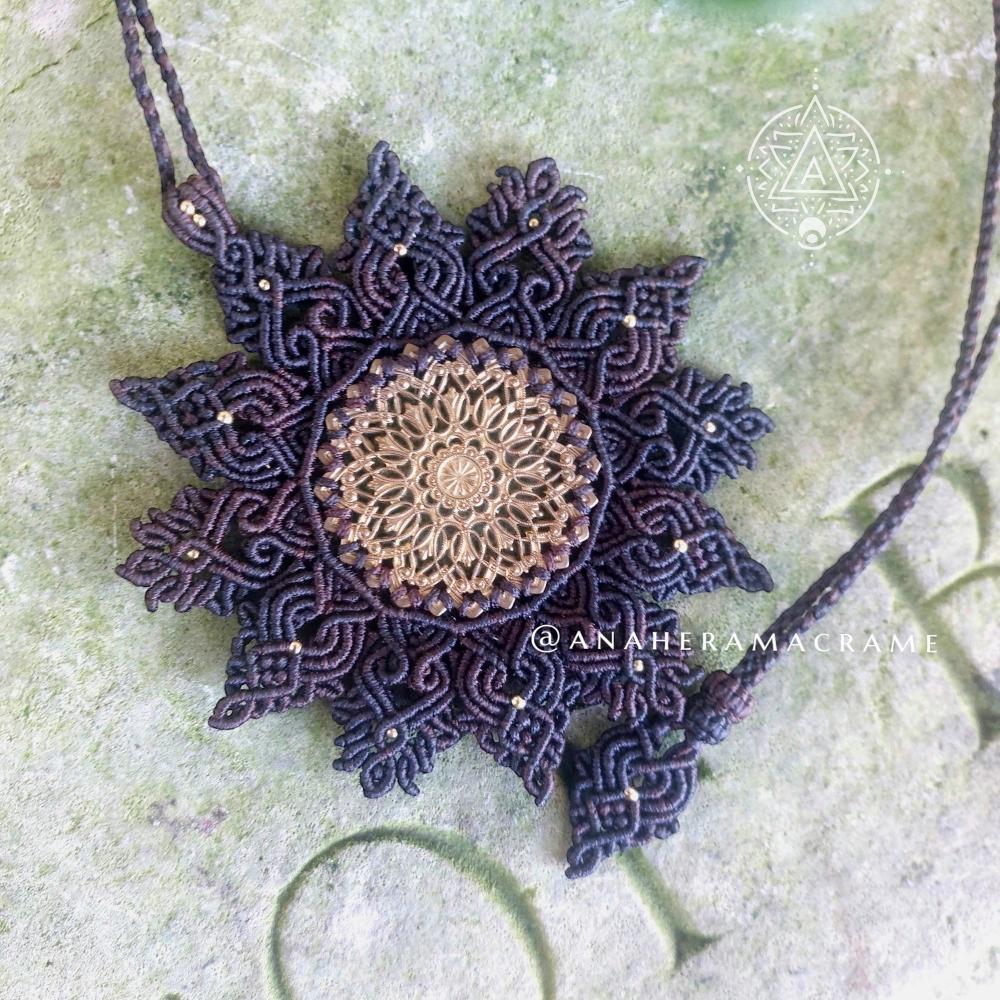 Handcrafted boho necklace with detailed macrame and brass filigree charm.  
