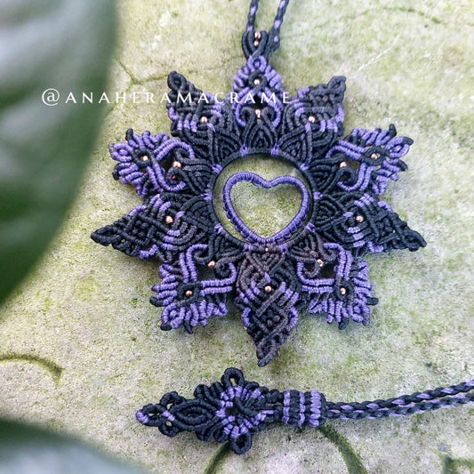 Handcrafted purple and black boho necklace with heart-shaped design.  

