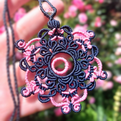 Blue and pink macrame mandala necklace with a concentric pink circle and glass bead.