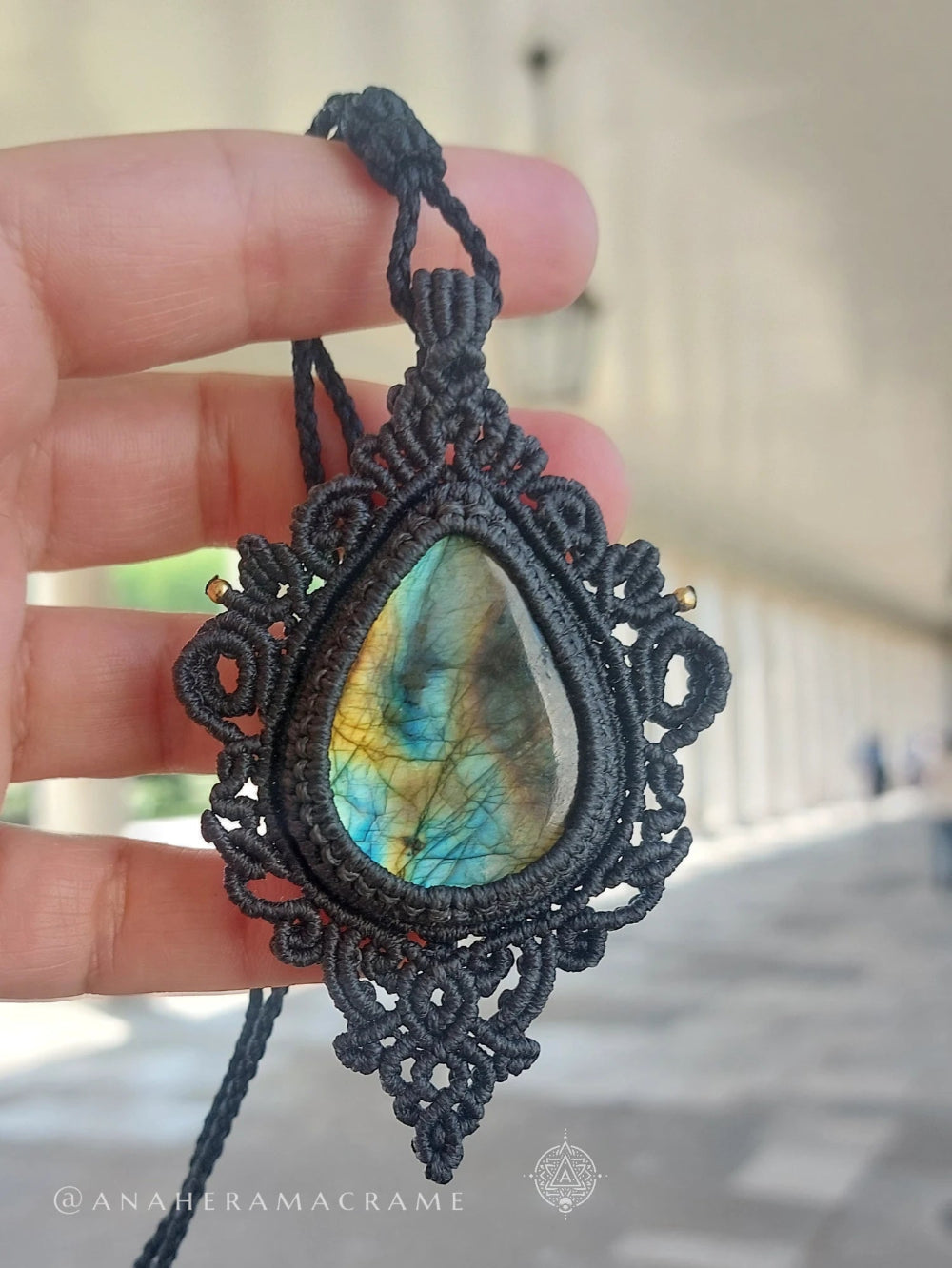 Vibrant labradorite crystal pendant with visible internal lines and colours, wrapped in handcrafted black cord work