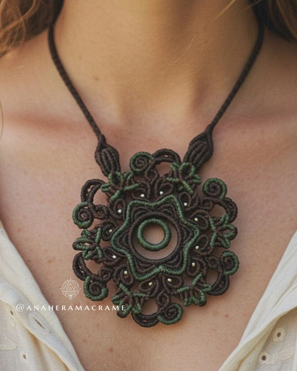 Close-up of a green macrame necklace on a person wearing a white top.