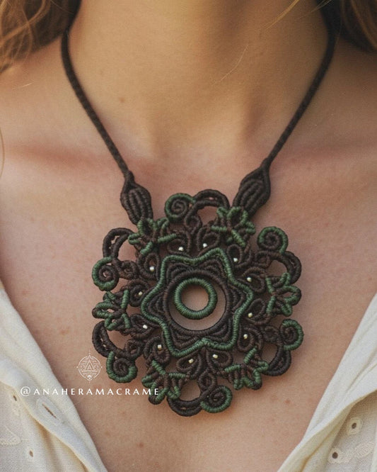 Close-up of a green macrame necklace on a person wearing a white top.