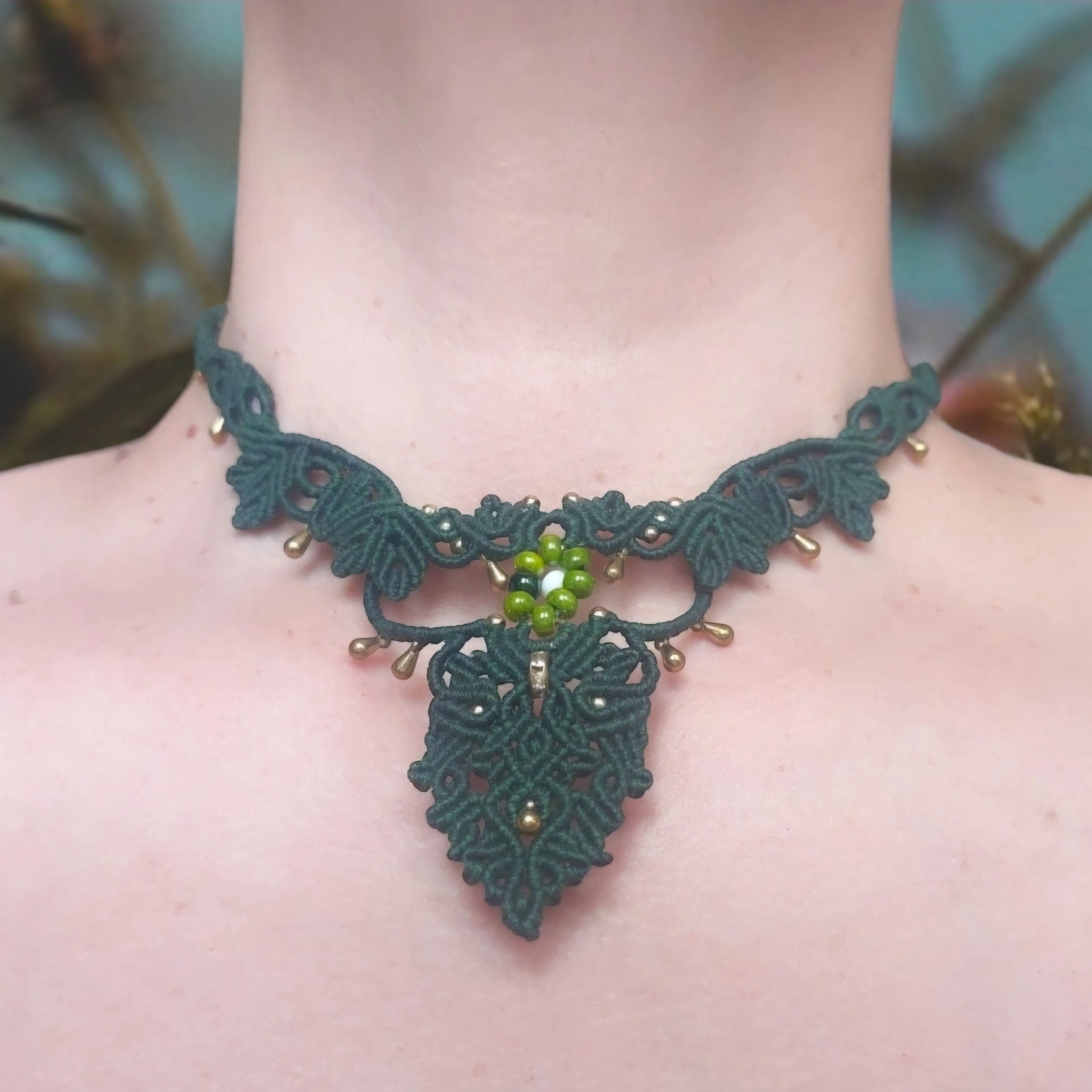 Handcrafted boho choker necklace featuring a green floral motif.
