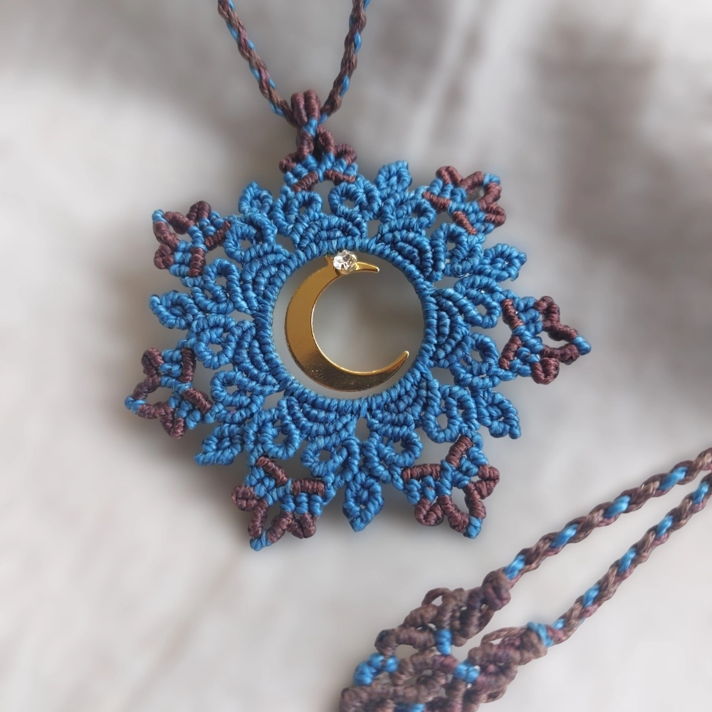 The light blue boho macrame mandala flaunts a crescent moon charm plated in 18K gold. Adjustable to 54cm/21.2 inches, including the pendant, it fits any neck with a slide lock feature.