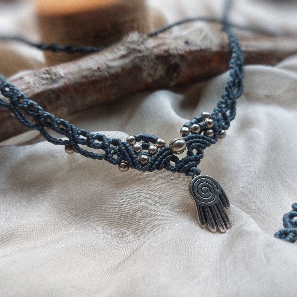 Boho macrame choker featuring a hand of hamsa charm and rose brass charm. This necklace is the perfect statement piece for any hippie-style outfit. This versatile piece can be worn as a crew neck necklace or even as a tiara.