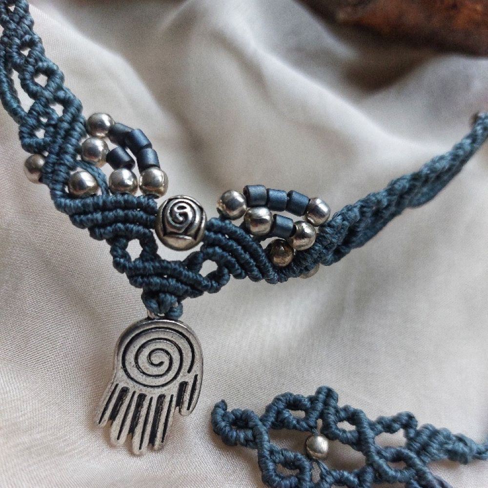 Boho macrame choker featuring a hand of hamsa charm and rose brass charm. This necklace is the perfect statement piece for any hippie-style outfit. This versatile piece can be worn as a crew neck necklace or even as a tiara.