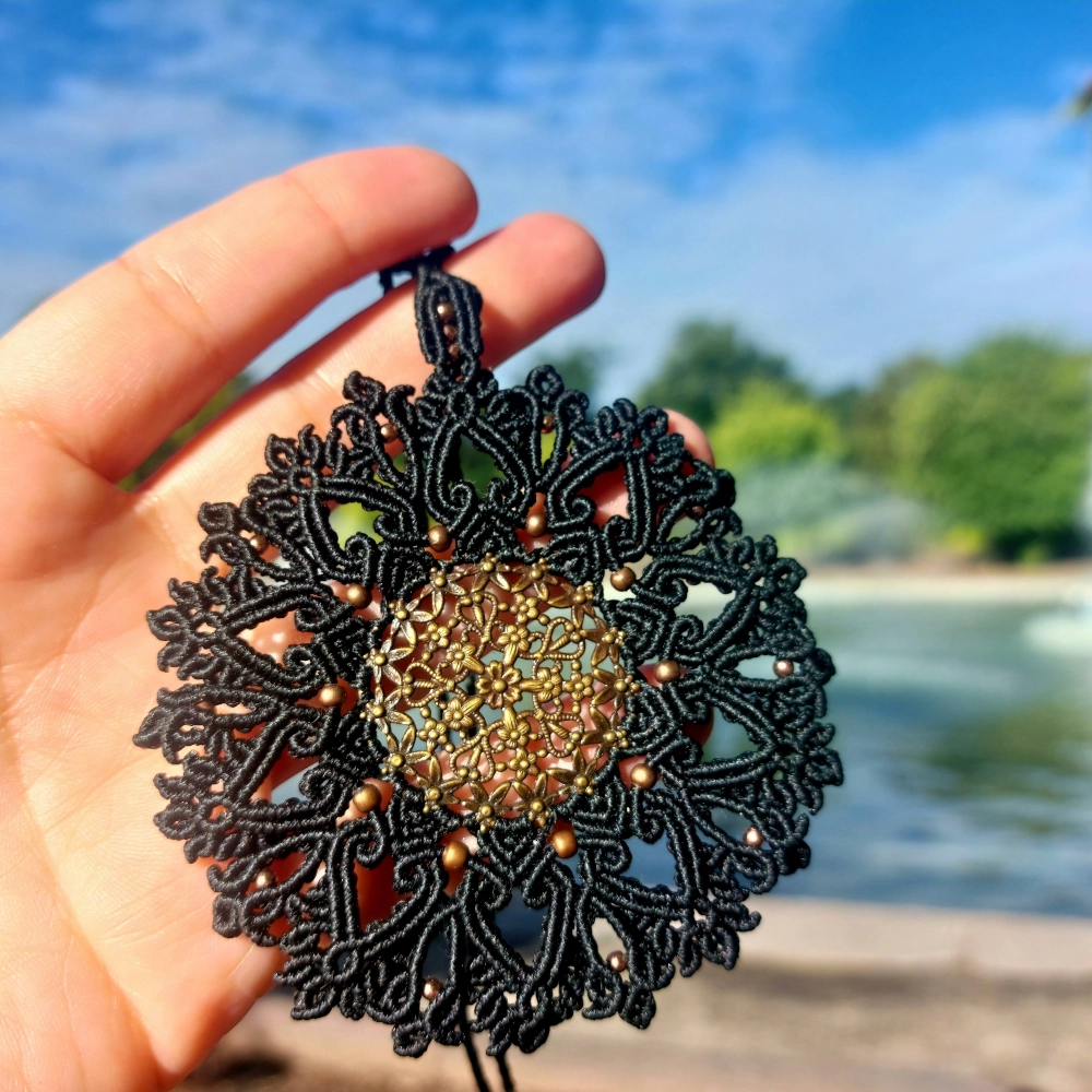 Handcrafted black macrame necklace showcasing detailed mandala pattern.