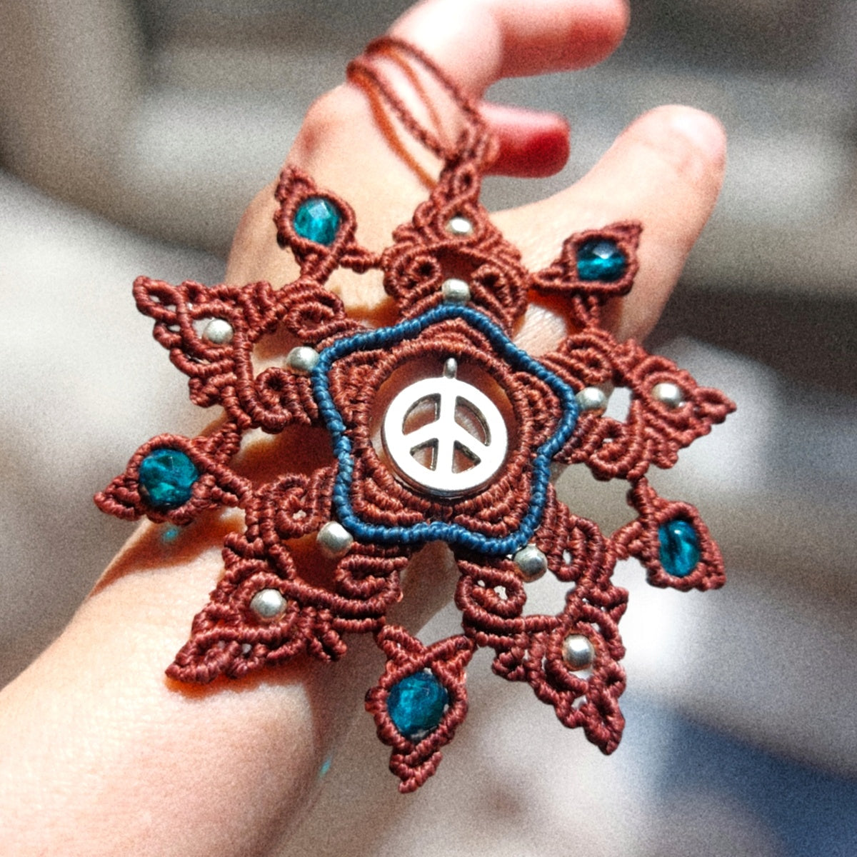 The Macrame Mandala Necklace features a peace symbol charm and brass beads. Measuring approximately 55cm /21.8 Inches in total length, the necklace is adjustable with a slide lock for a comfortable fit.