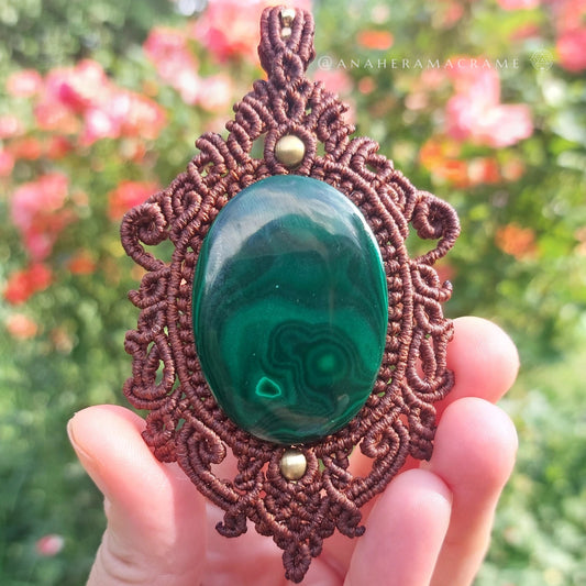 Earth-toned macrame necklace with polished malachite centerpiece and detailed knotwork.