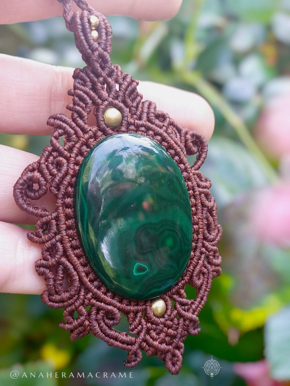 Green malachite gemstone necklace with ornate brown macrame design and brass embellishments.