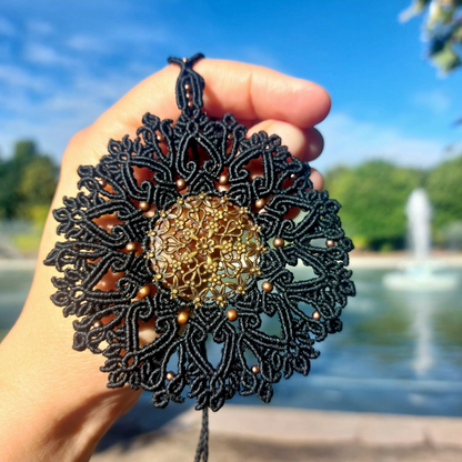 Bohemian-style macrame necklace with adjustable length and brass charm.