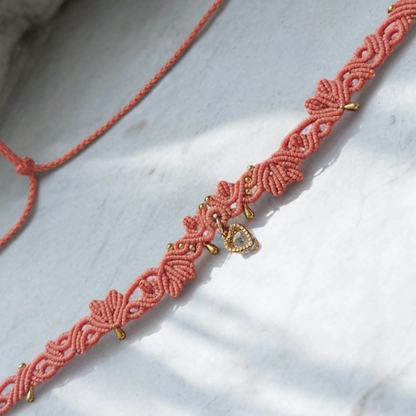 Romantic macrame choker with a coral design, glittering Cubic Zirconia heart charm, and sliding lock for a versatile fit.
